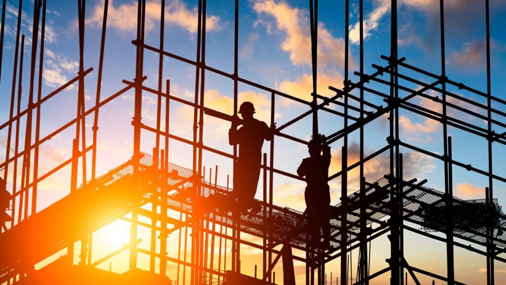 two men standing on scaffolding