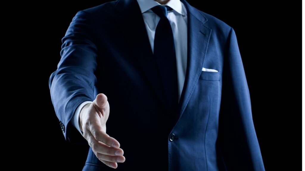 man in suit giving handshake
